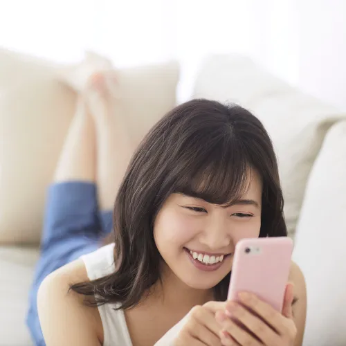 ソファでスマホに向かう女性